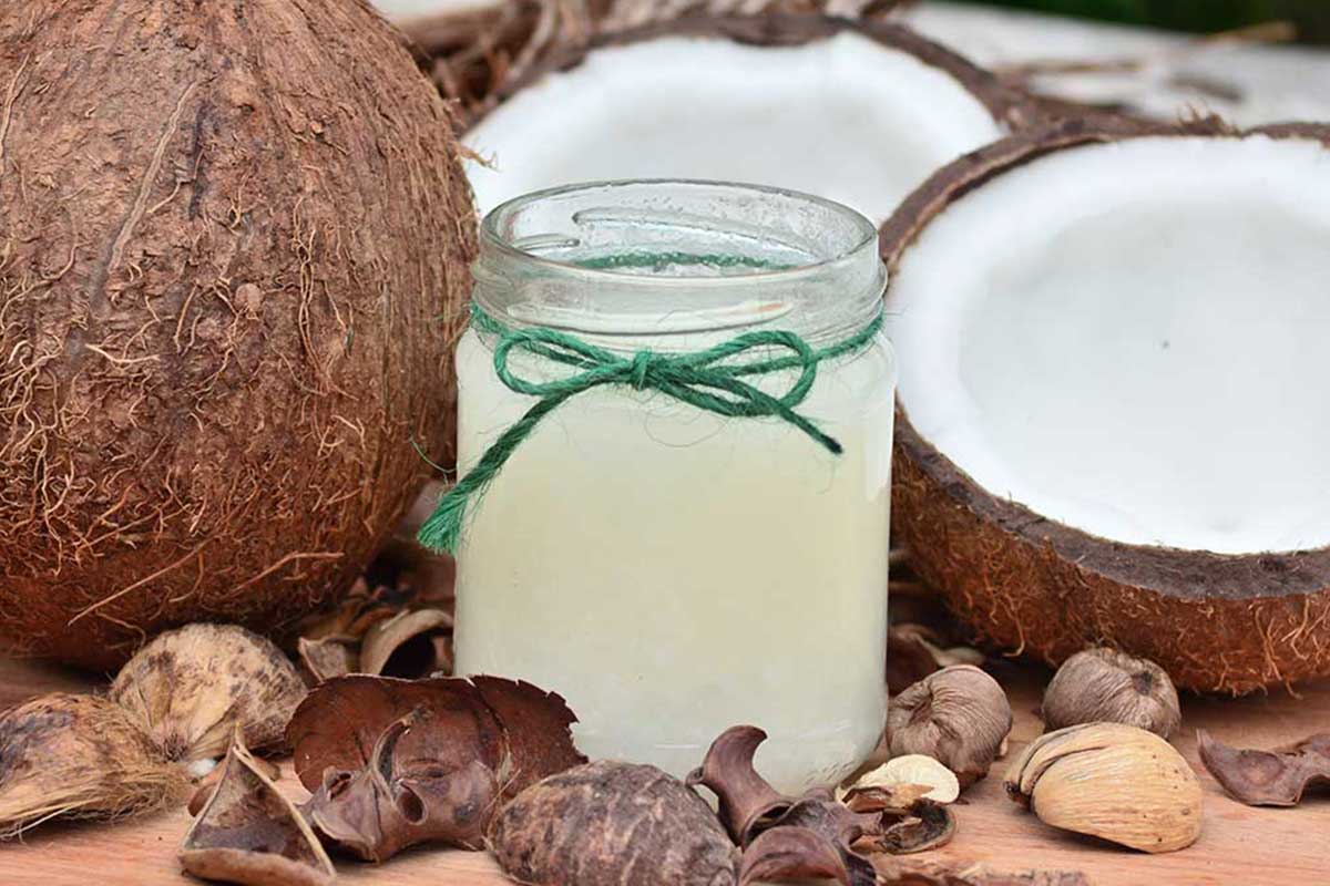 Kokosöl im Glas mit Kokosnüssen als Deko